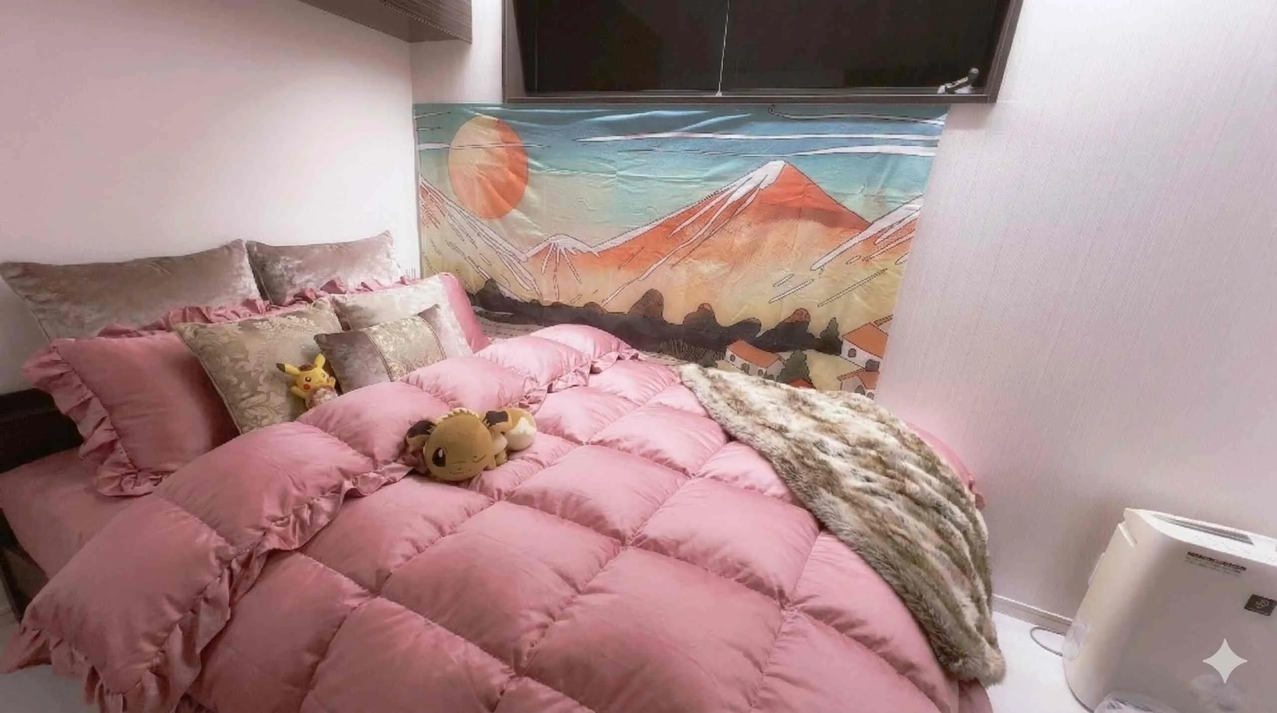 Private bedroom with a double bed, pink linens, and a Mount Fuji tapestry.