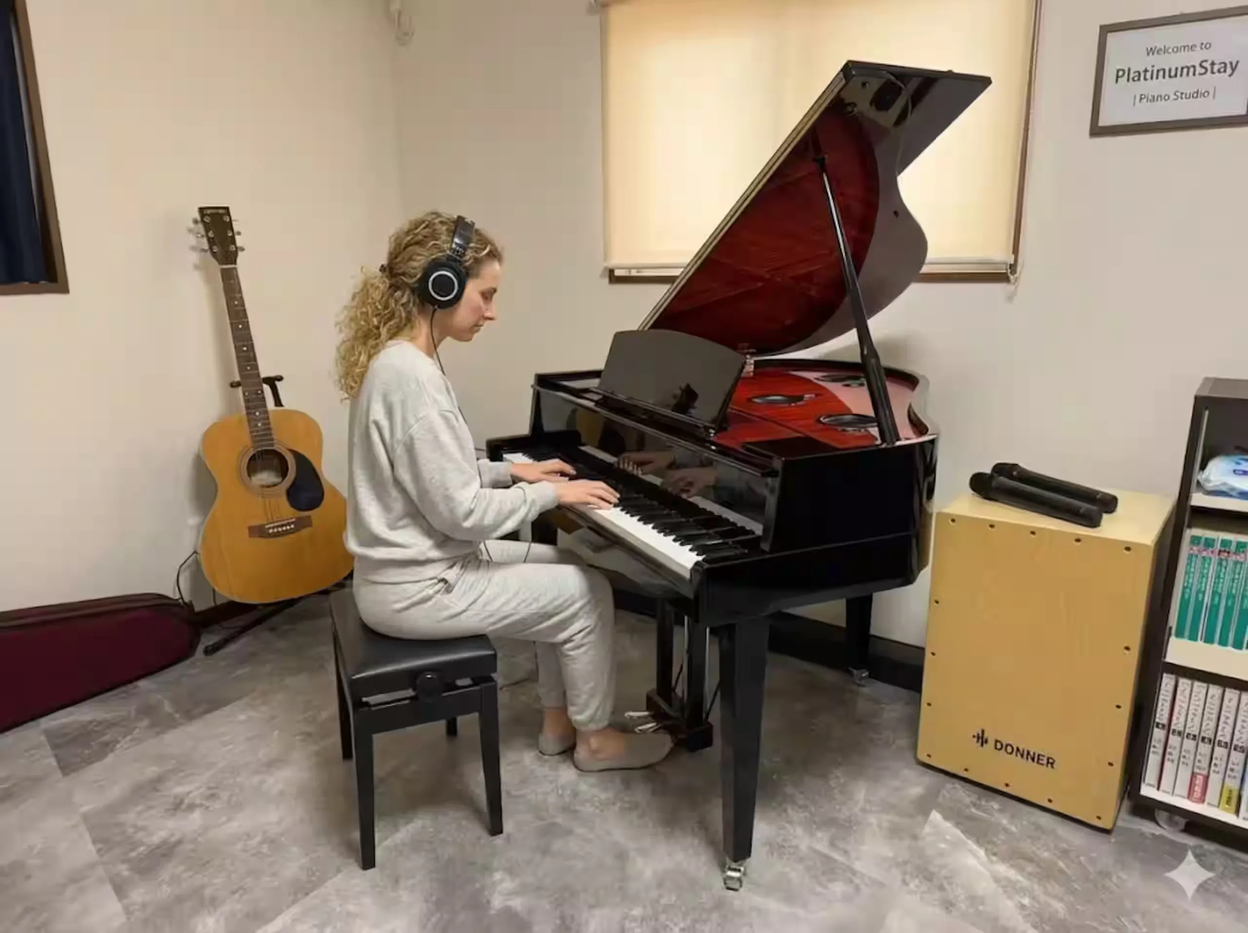 Guest playing a black Yamaha hybrid piano in the dining studio.