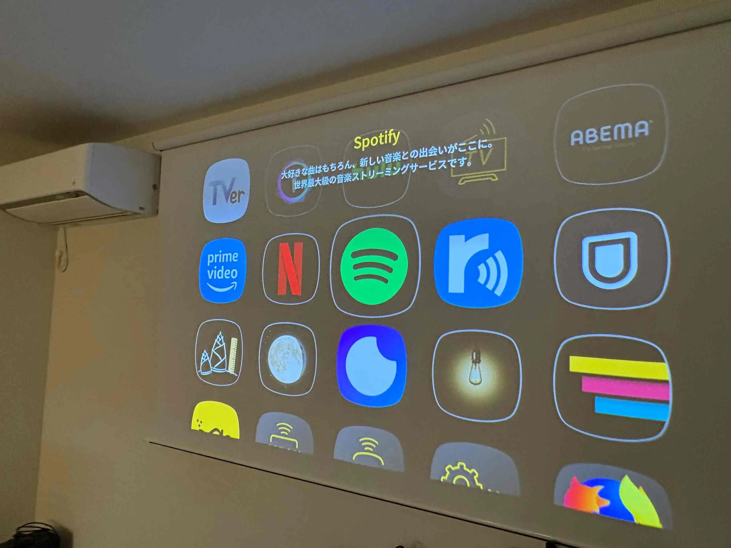 Home theater projector showing a streaming interface on a pull-down screen.